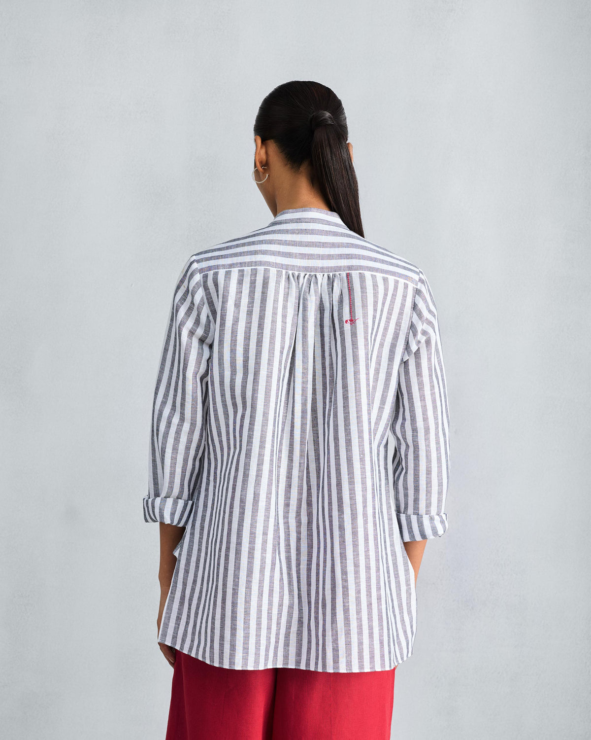 Back of a charcoal striped mandarin collar top with a red motif.