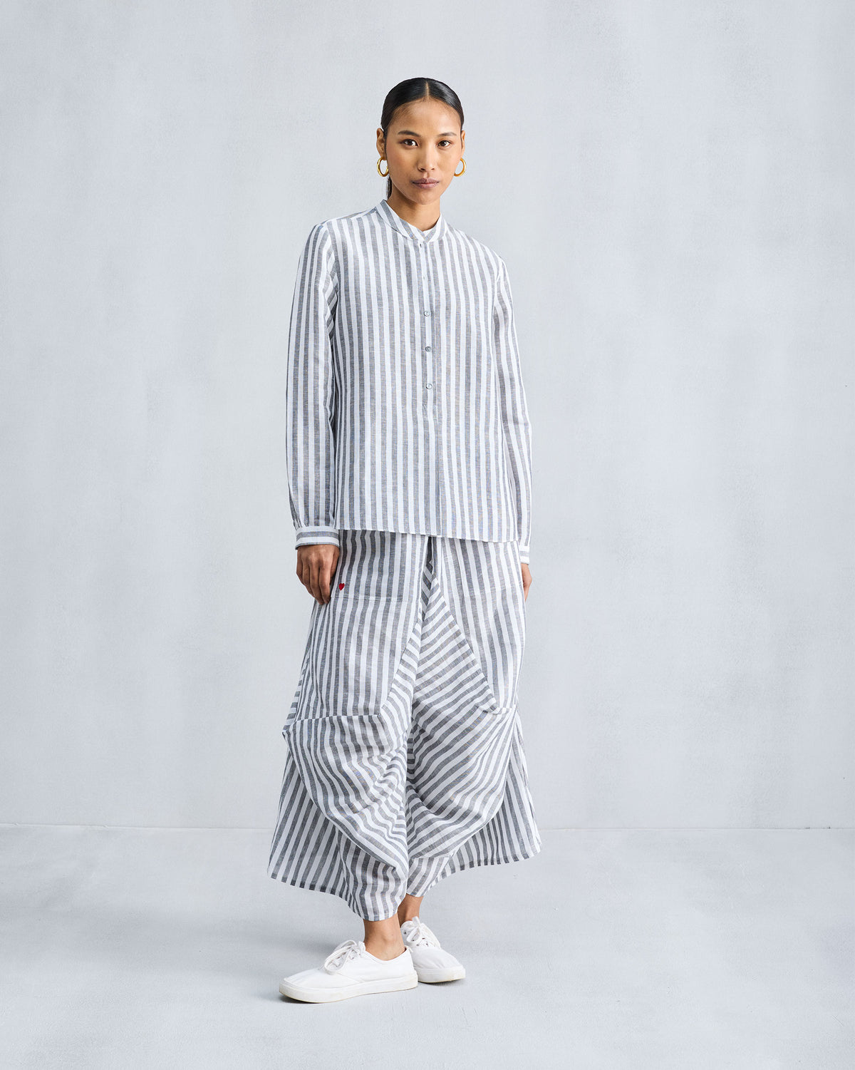 Person wearing a charcoal and white striped mandarin collar top.