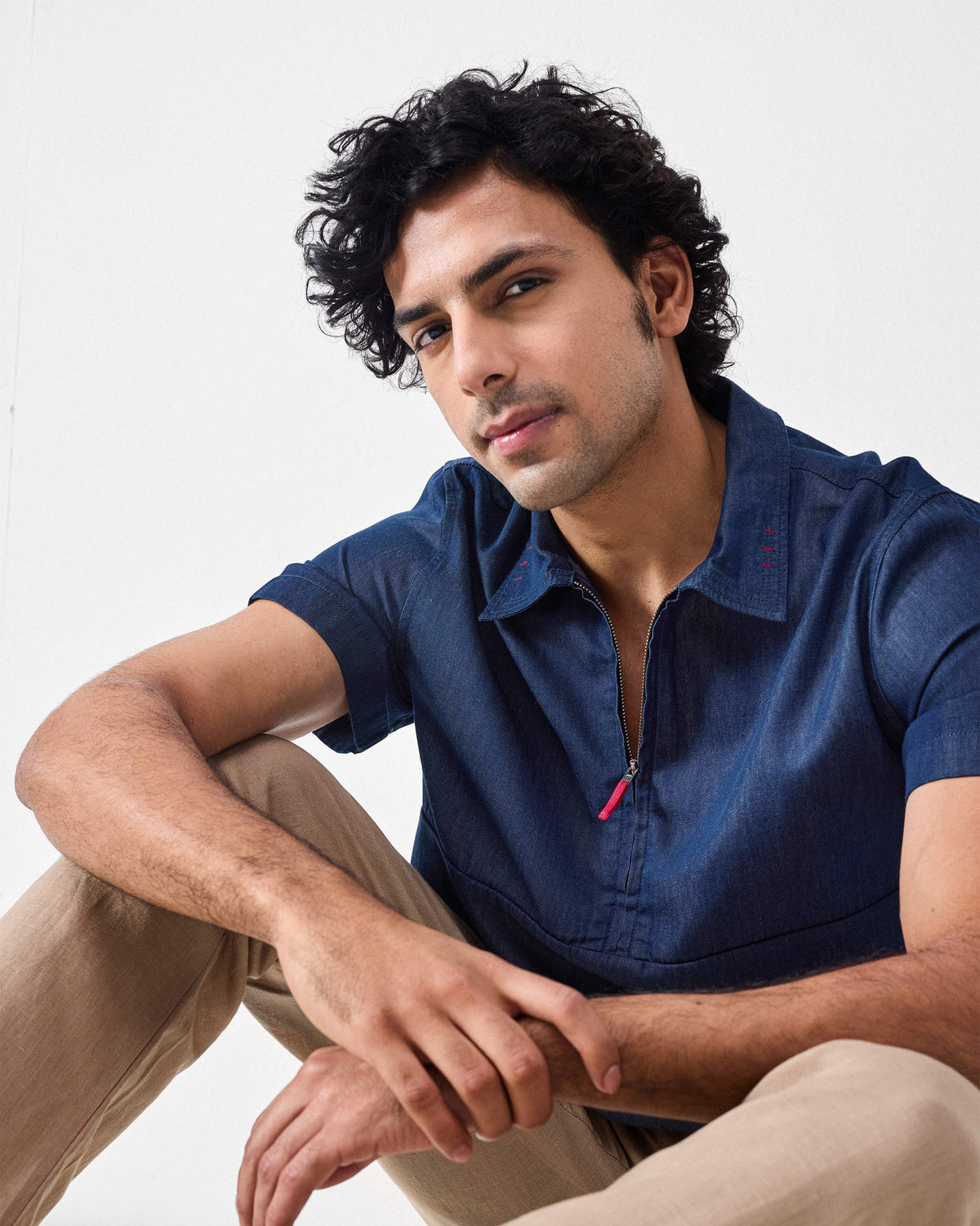 Person wearing a denim Konbini Shirt with a half-zip and red collar accents.