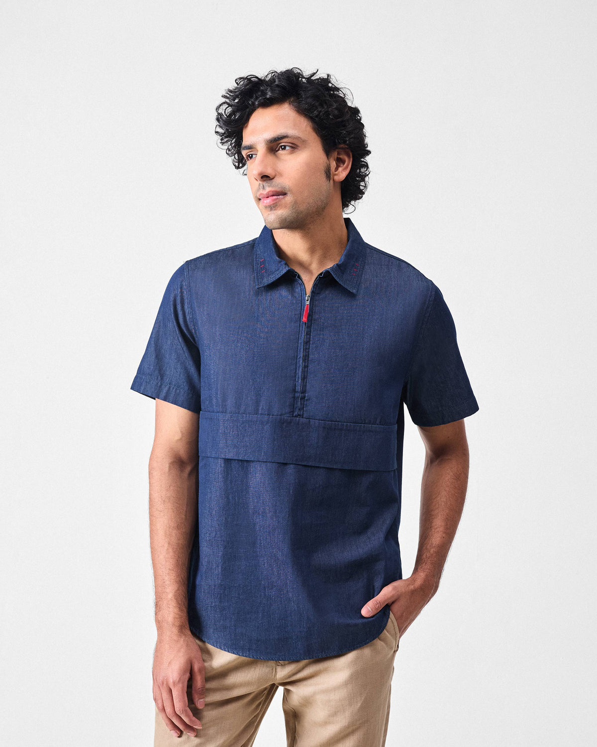 Person wearing a denim Konbini Shirt with a half-zip and horizontal chest panel.