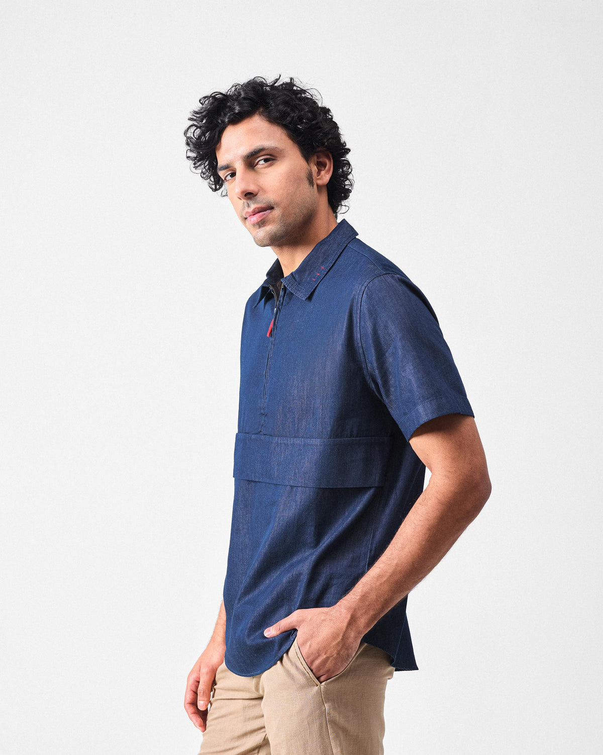 Side view of a denim Konbini Shirt showing the chest panel and red zipper pull.
