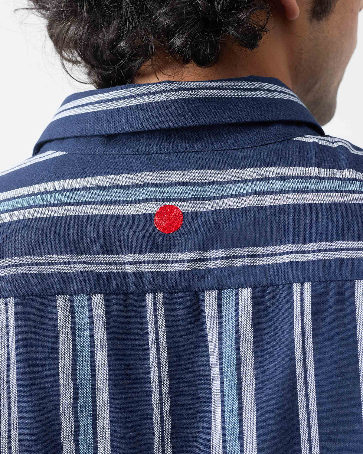 Close-up of the back yoke and red detail on a blue and navy Comoros kurta.