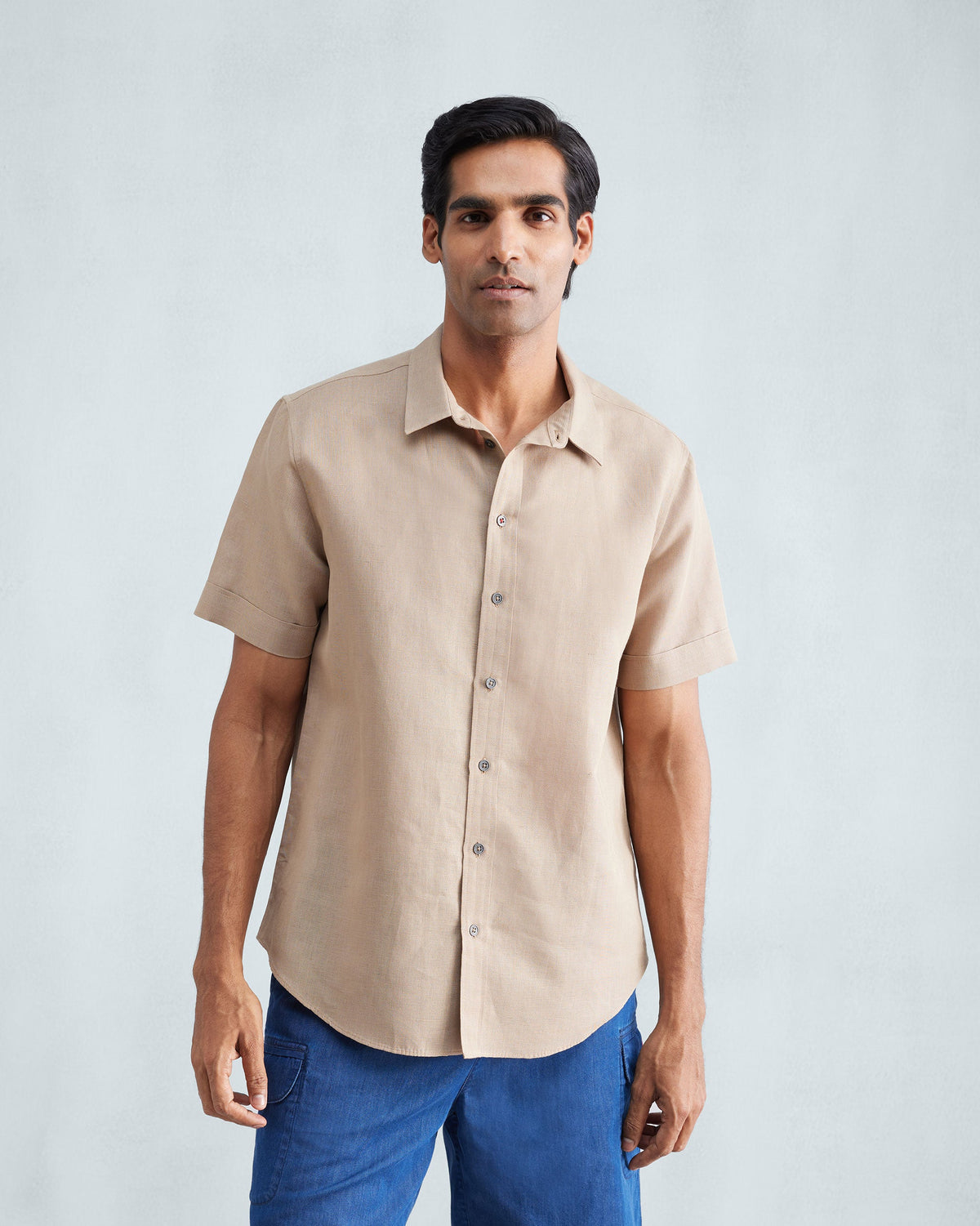 Person wearing a beige half sleeve shirt.