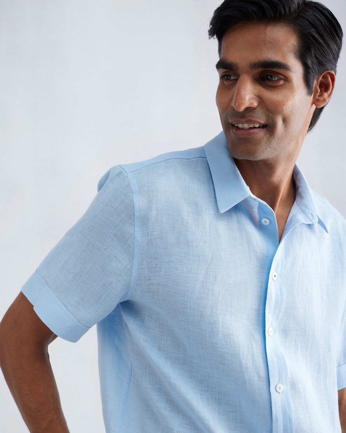 Person wearing a light blue half-sleeve shirt showing the collar and cuff.