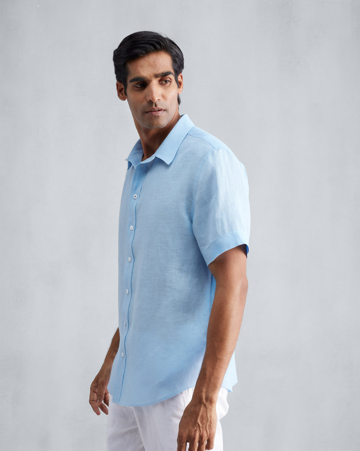 Side view of a light blue half-sleeve linen shirt.