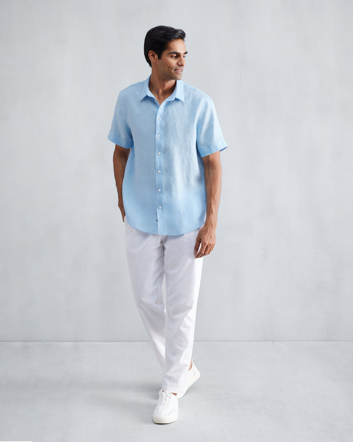 Person wearing a light blue half-sleeve shirt untucked at full length.