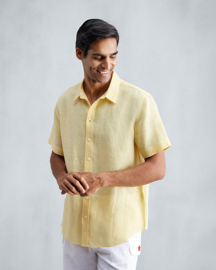 Person wearing a lemon linen half-sleeve shirt with a classic collar.