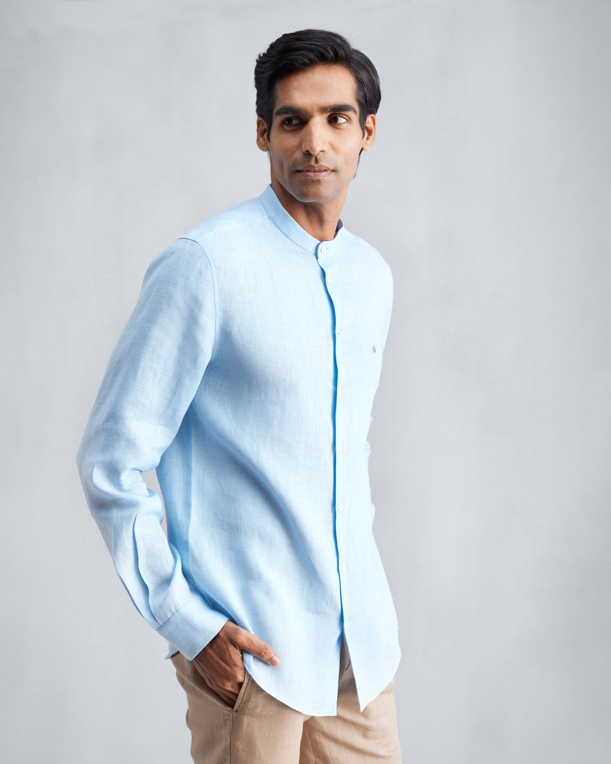 Person wearing a light blue Nehru collar Nawab shirt with a chest pocket.