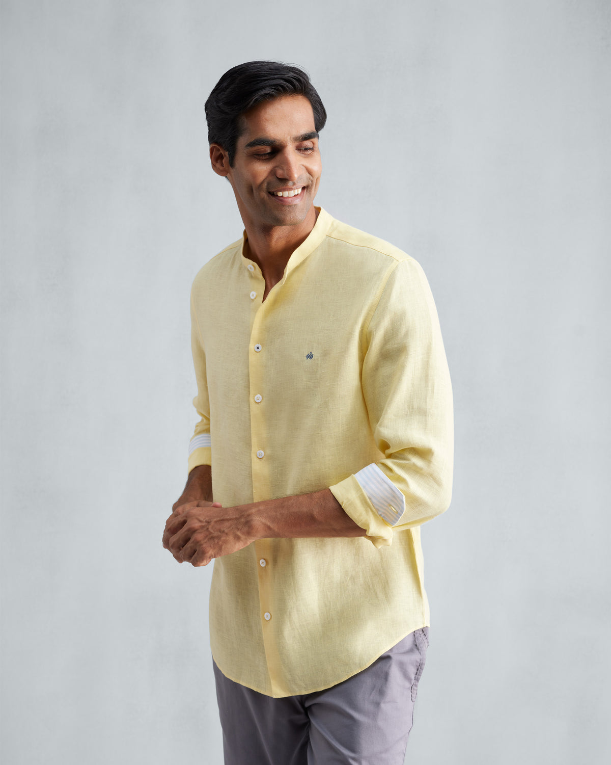 Person wearing a lemon Nawab shirt with rolled sleeves showing striped cuff trim.