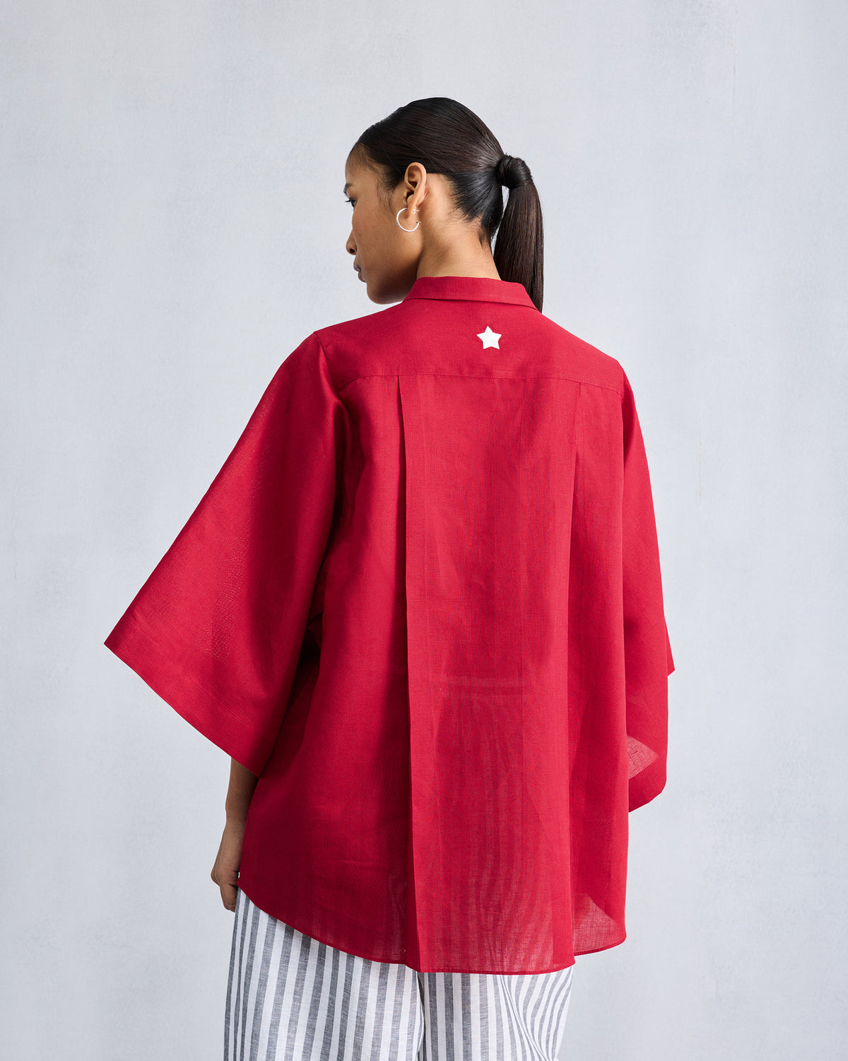 Back of a red shirt with a small white star on the yoke.
