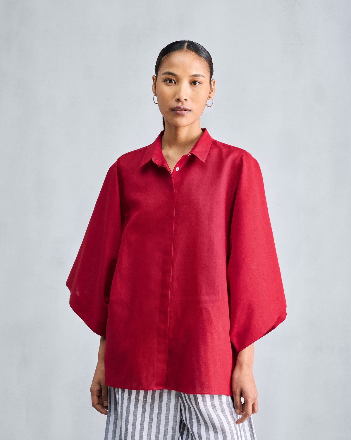 Person wearing a red drop armhole shirt.