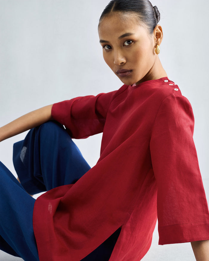 Person wearing a red High Slit Top with white shoulder buttons.