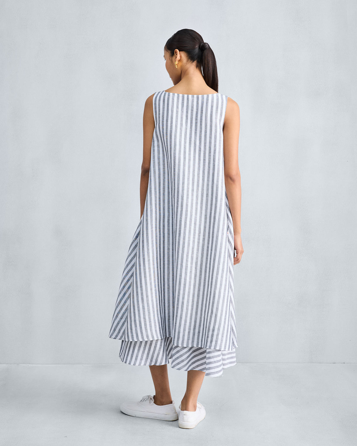 Back of a charcoal and white striped double-layer dress with a tiered hem.