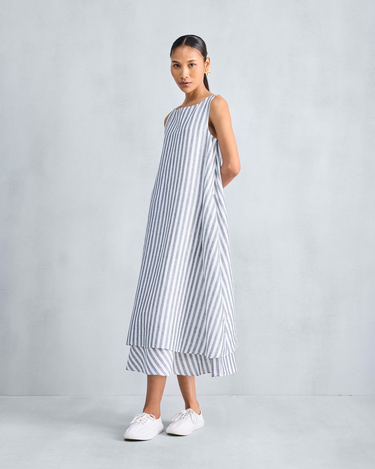 Three-quarter view of a striped double-layer dress showing the bias hem layer.