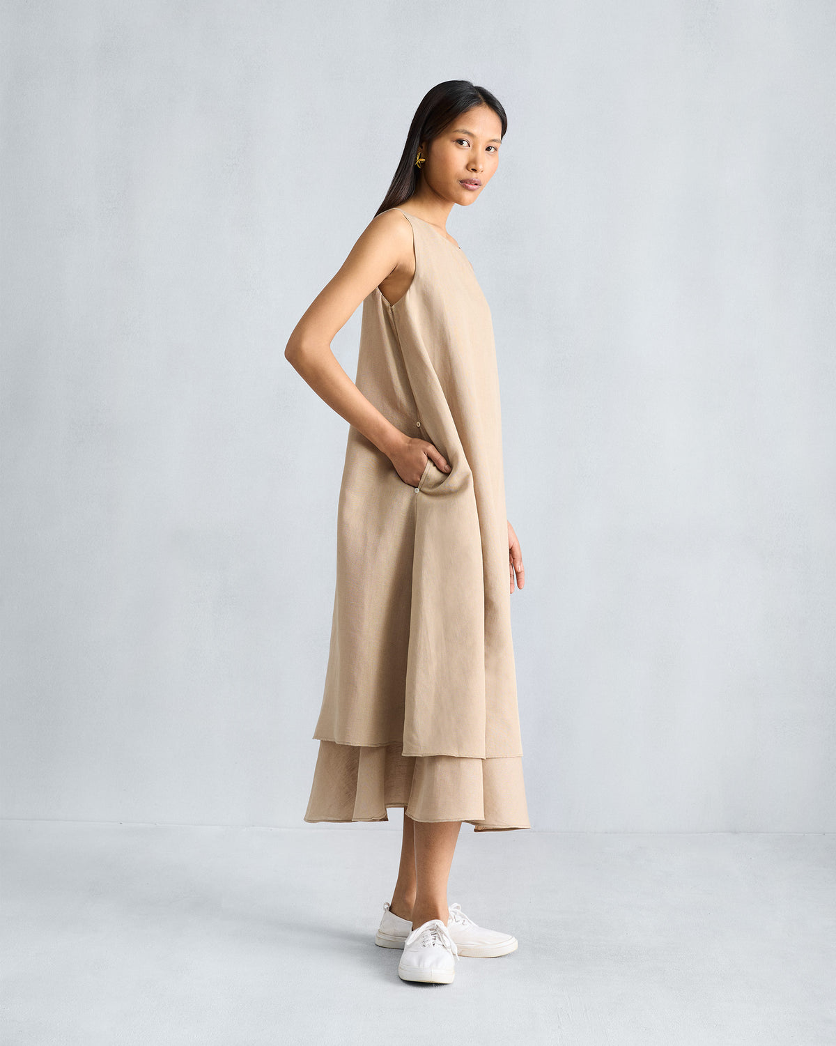 Side view of a beige Double Layer Dress with a side pocket.