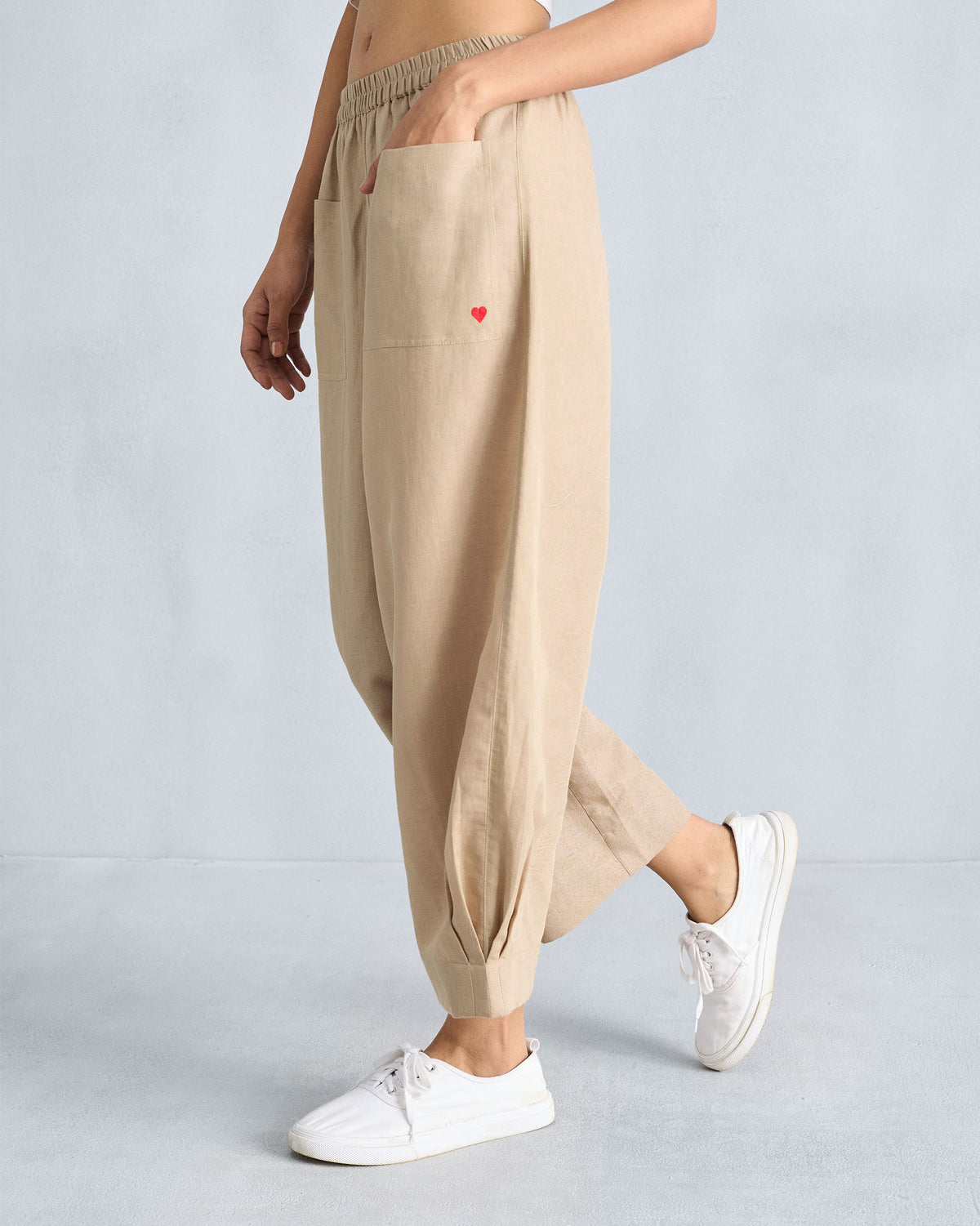 Side view of beige serene pants with a wide leg tapering at the ankle.