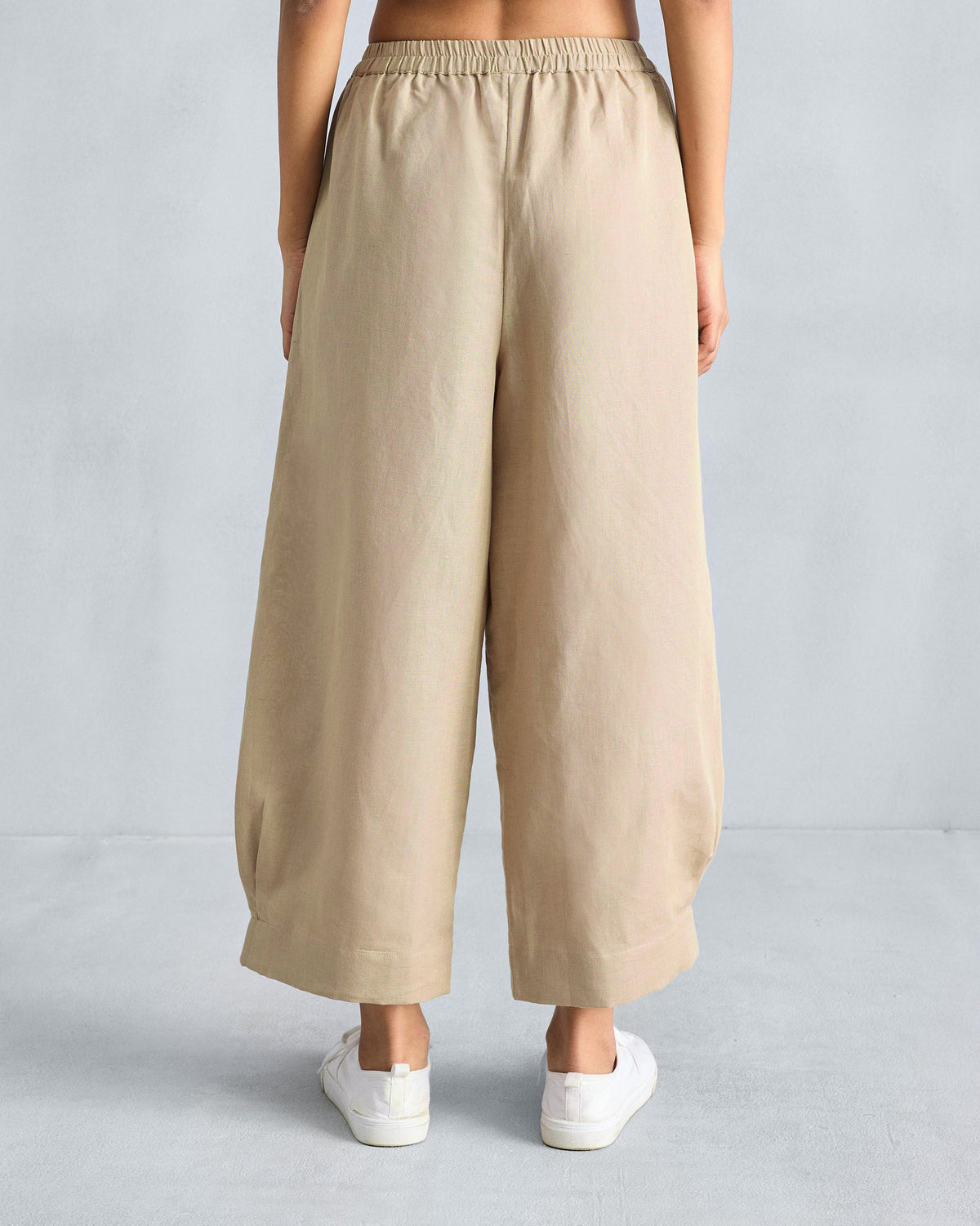 Back of beige serene pants with an elastic waist and tapered hems.