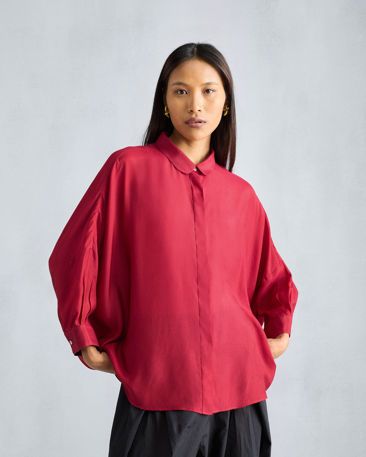 Person wearing a red Boxy shirt with a Peter Pan collar and balloon sleeves.