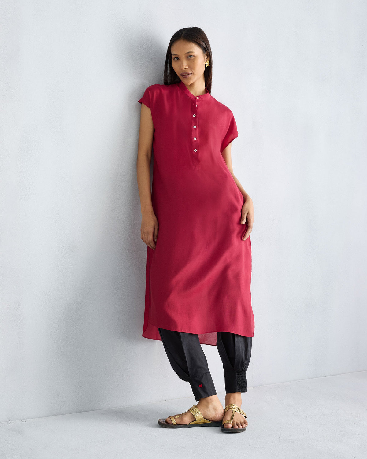 Person wearing a red short sleeve kurta with a band collar.