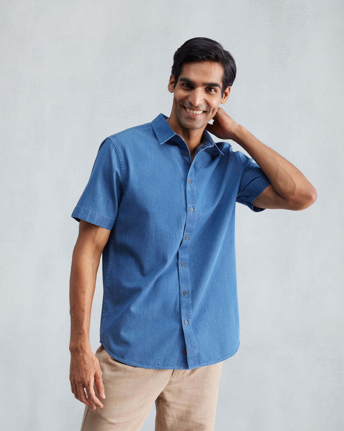 Person wearing a denim half sleeve shirt.