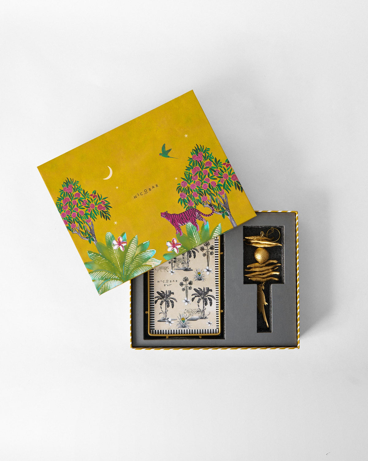 Madagascar box with a tiger jungle lid over a palm-print frame and gold charm.