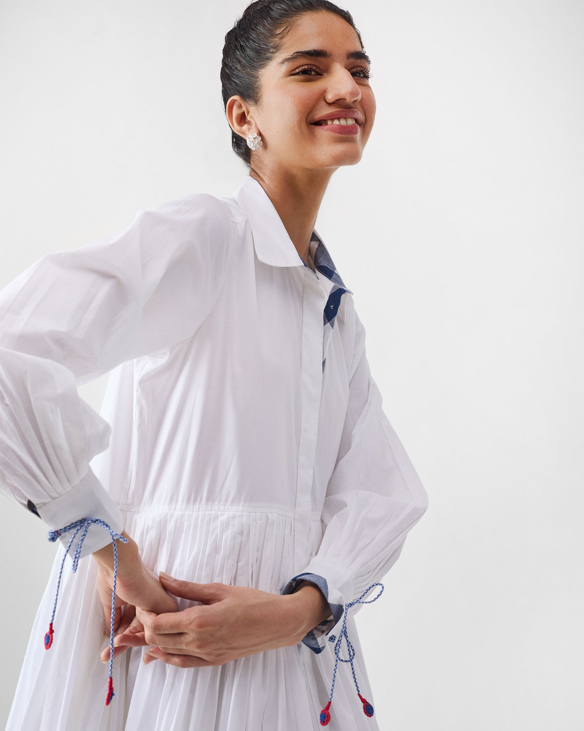 White Puritsu shirt dress with billowy sleeves and blue cuff ties.