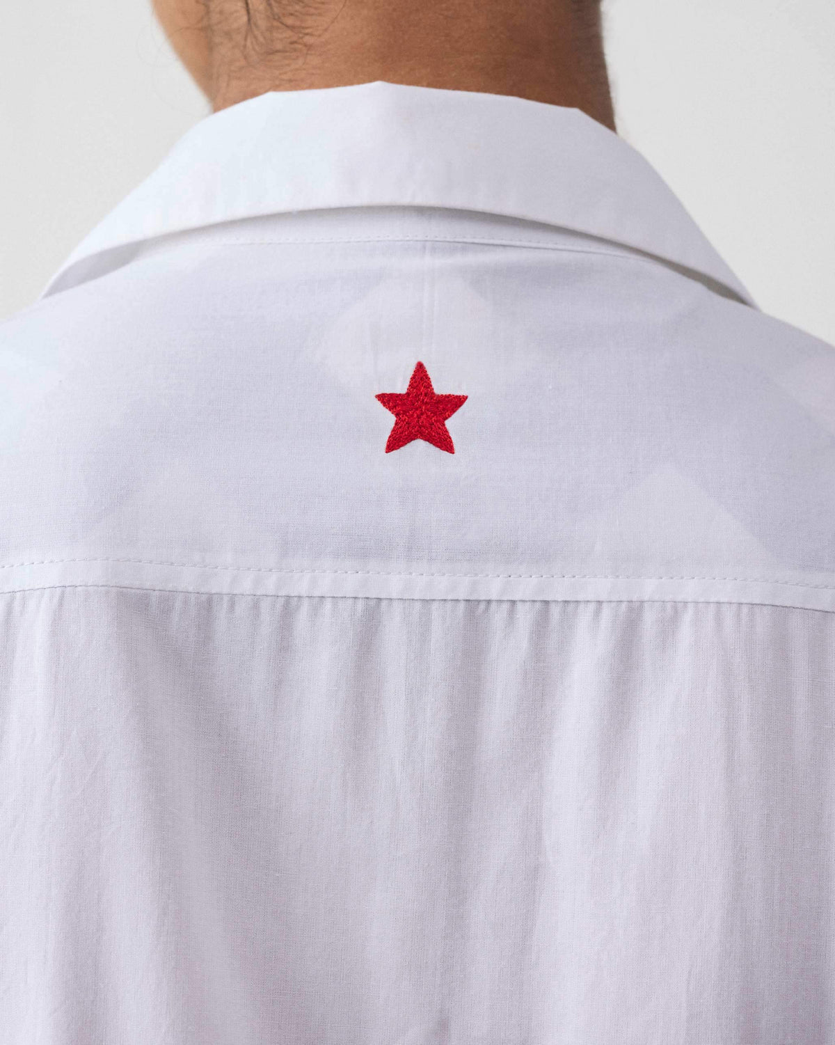 Close-up of a red embroidered star on the back of the Puritsu dress.