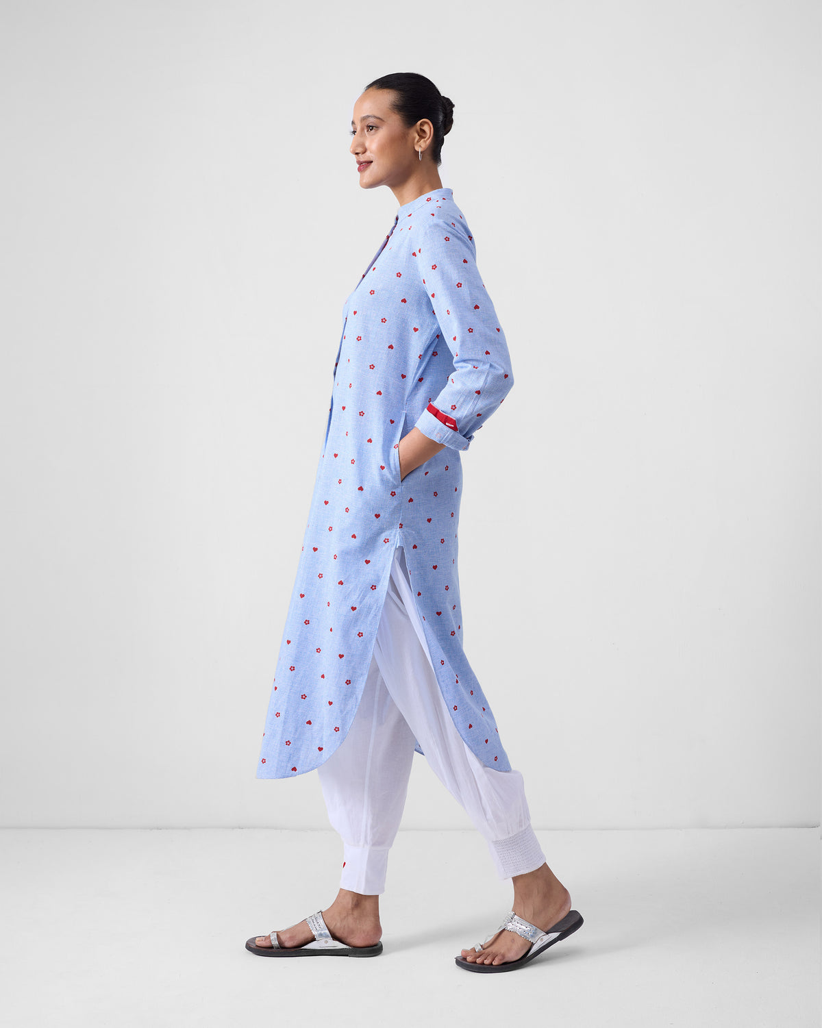 Side view of a long blue kurta with red motifs and a deep side slit.