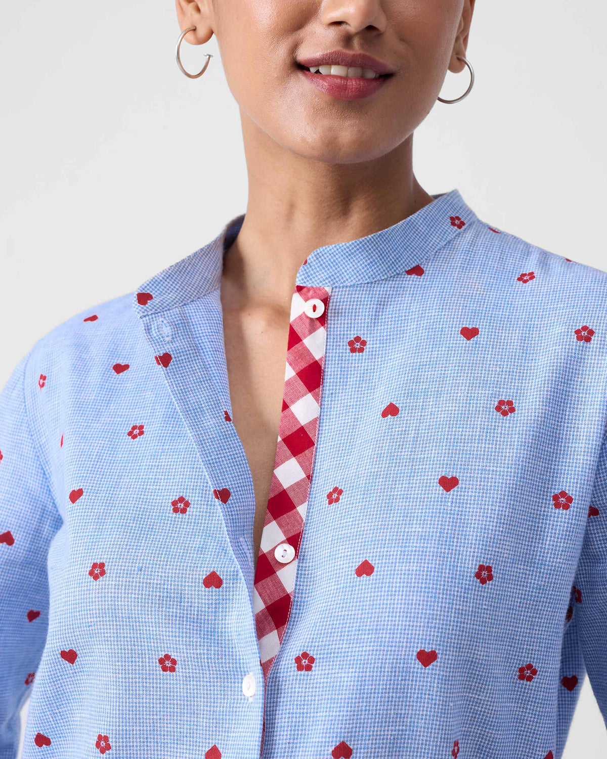 Close-up of a blue check kurta collar with red motifs and a gingham placket.