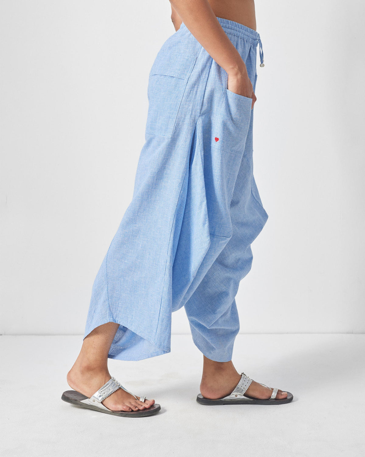 Side view of blue and white checked Yoka trousers with a red heart on the pocket.