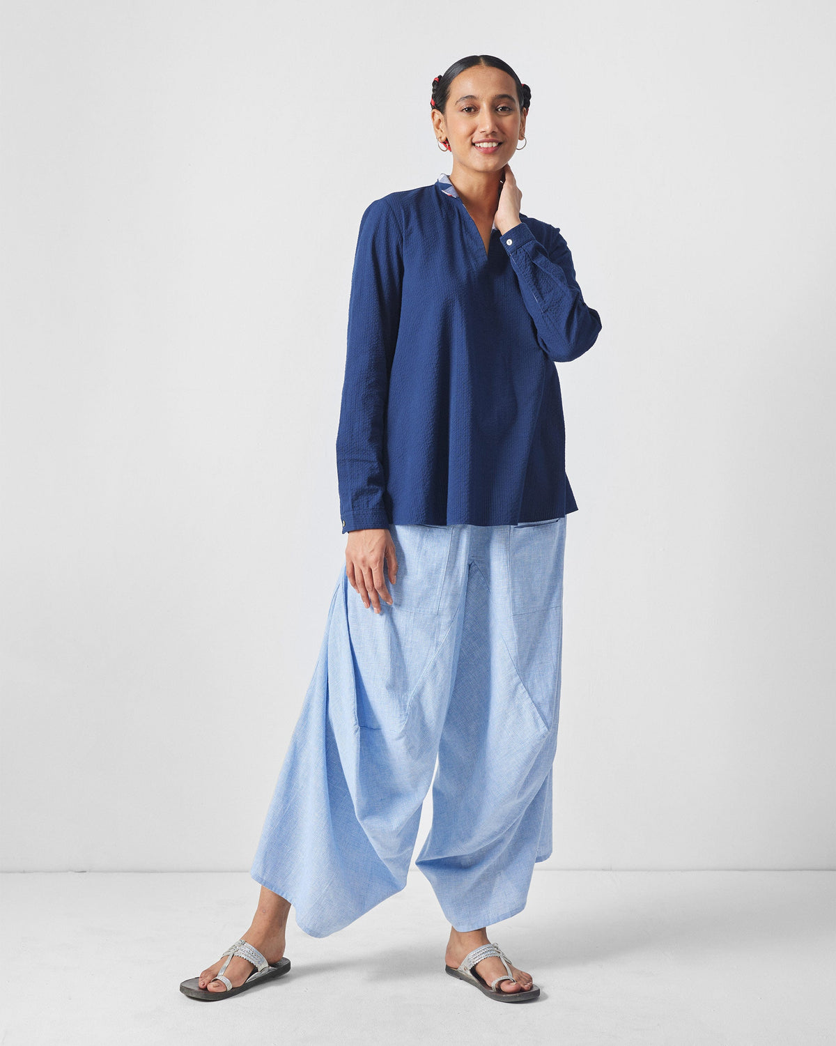 Blue and white checked Yoka trousers showing the draped wide-leg fit.