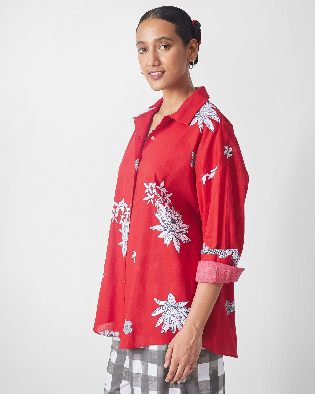 Side view of a red oversized shirt with white flowers.