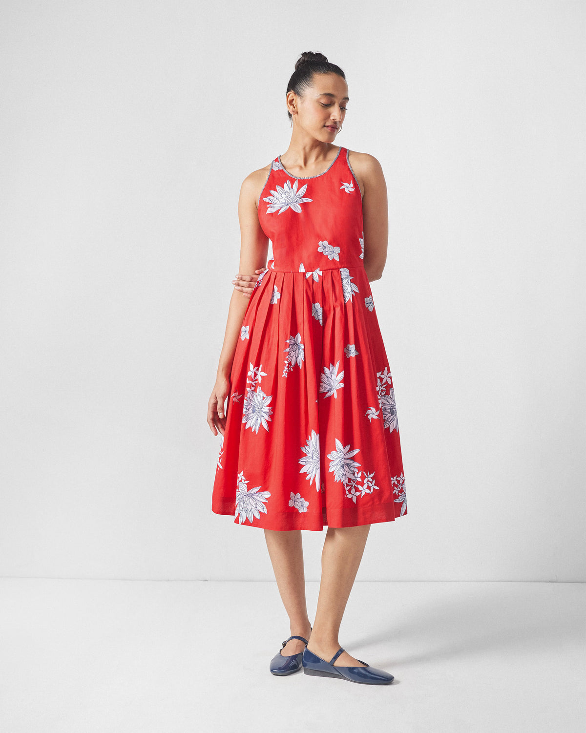 Person wearing a red Kaito Dress with white lotus blooms and a gathered waist.