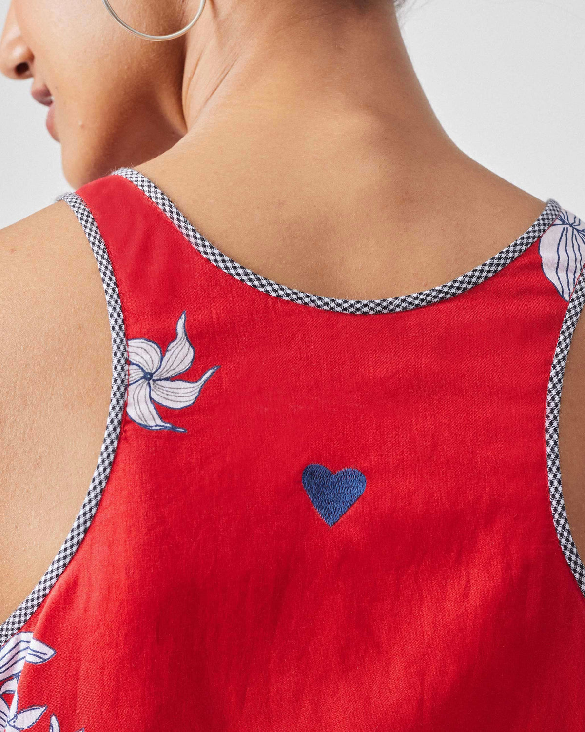 Close-up of a blue embroidered heart on the back of a red Kaito Dress.