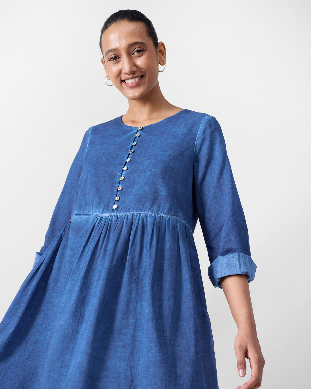 Person wearing a blue Geisha Kurta with a button placket and gathered waist.