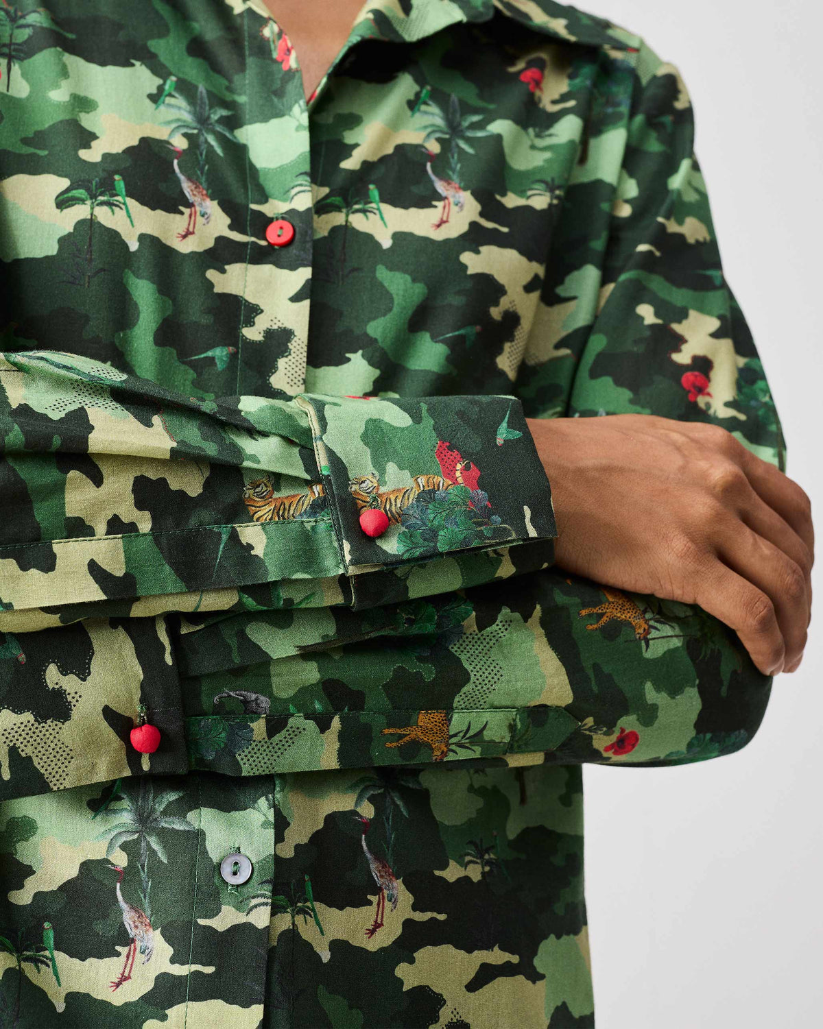 Close-up of a green Tropico Shirt showing wildlife motifs and a red button.