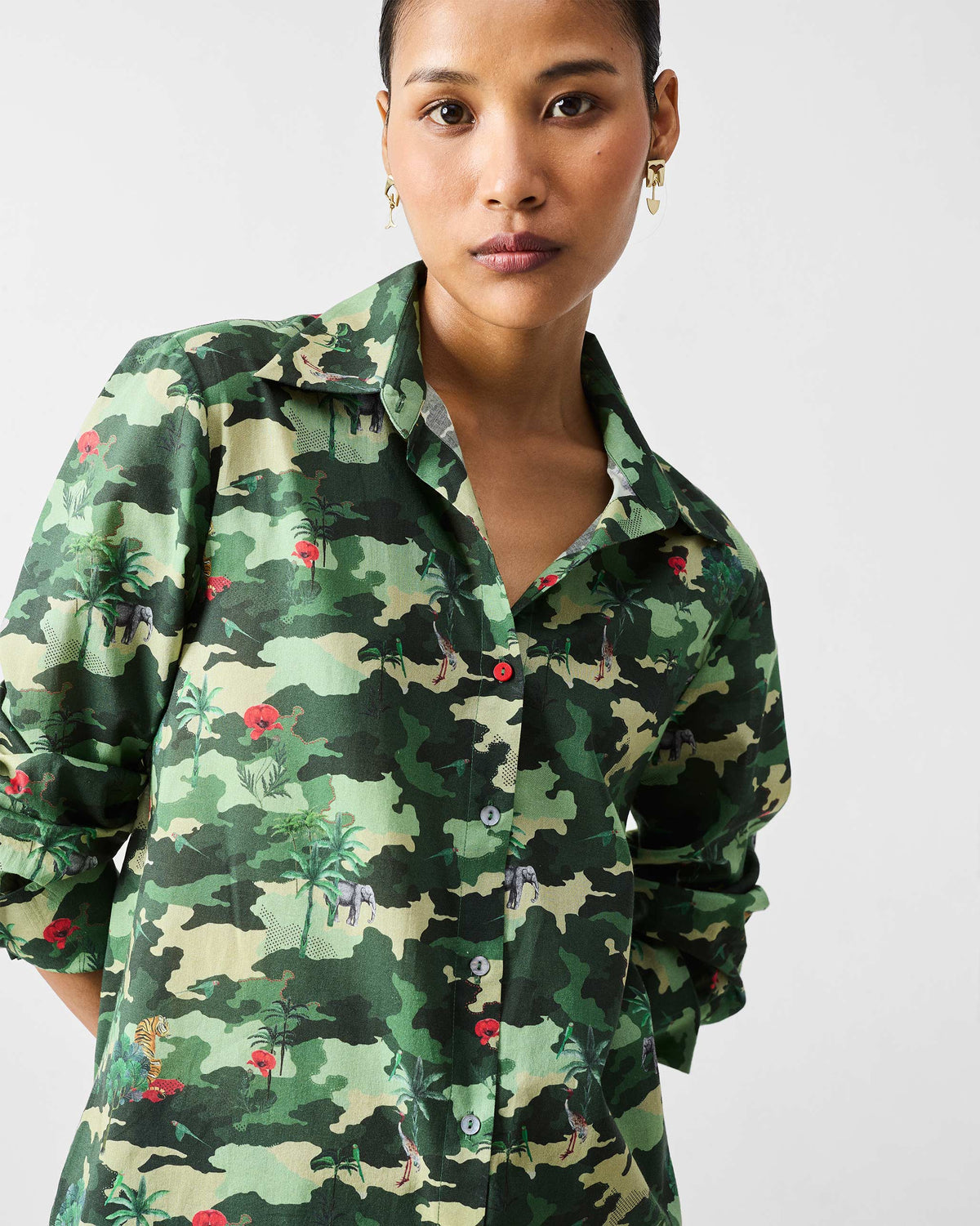 Person wearing a green camouflage Tropico Shirt with elephant and palm motifs.