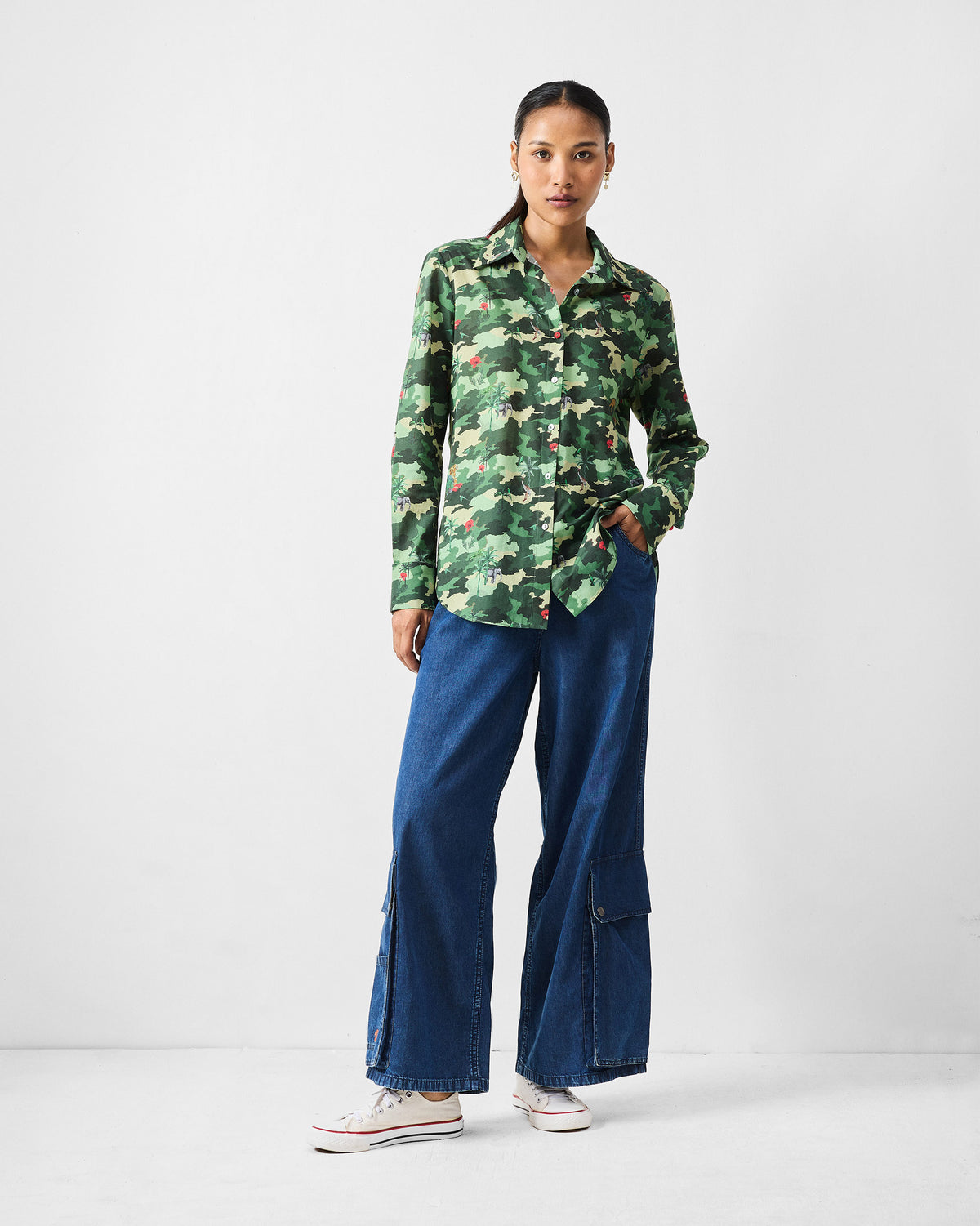 Person wearing a green camouflage Tropico Shirt with a relaxed full-length fit.