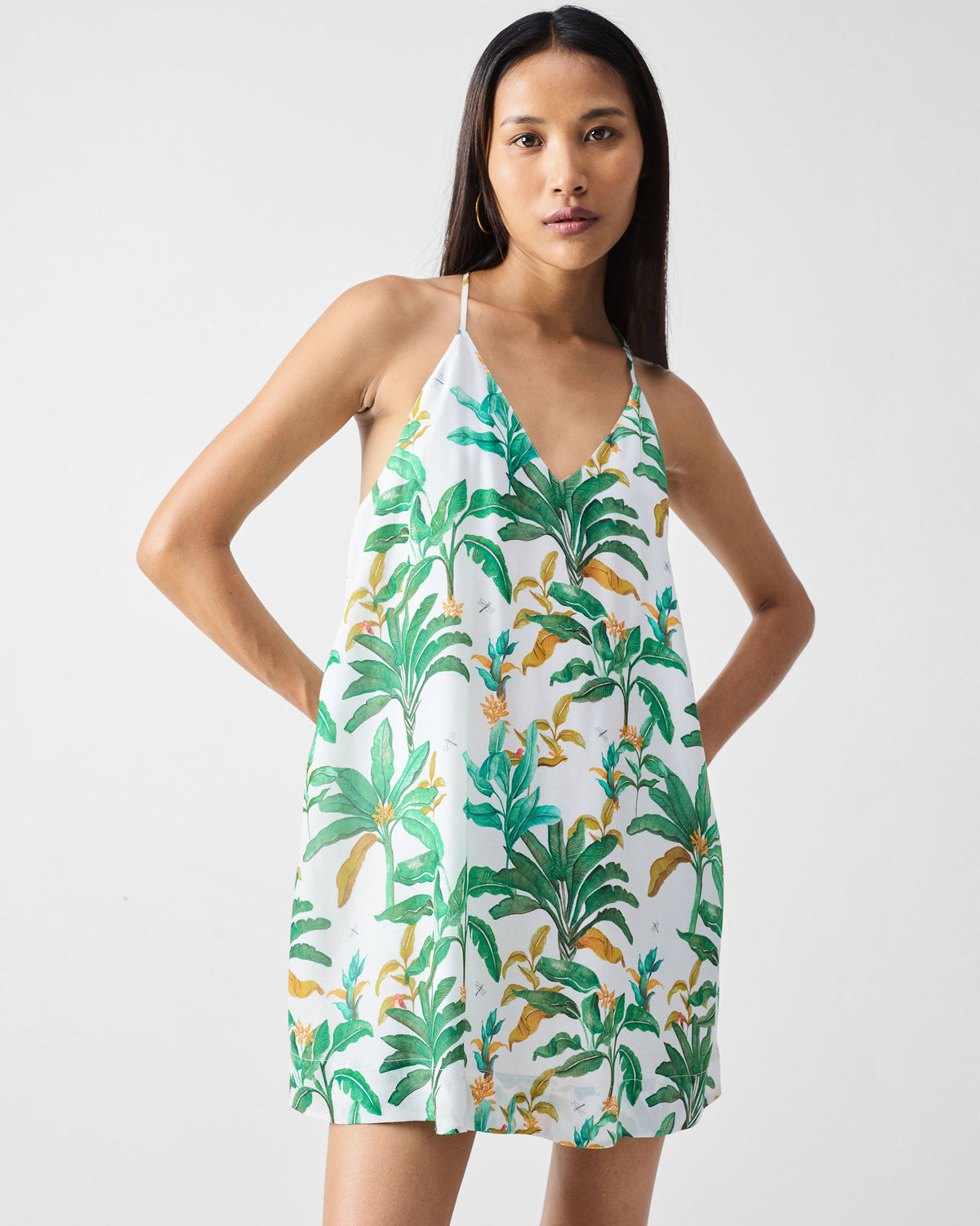 Person wearing a green printed salem dress with a V-neck and spaghetti straps.