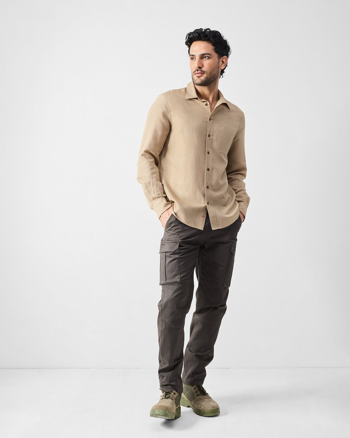 Person wearing deep olive Boscage cargo pants with flap thigh pockets.