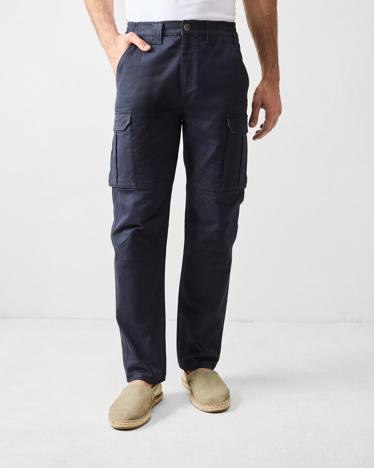 Person wearing navy Boscage cargo pants with flap thigh pockets.