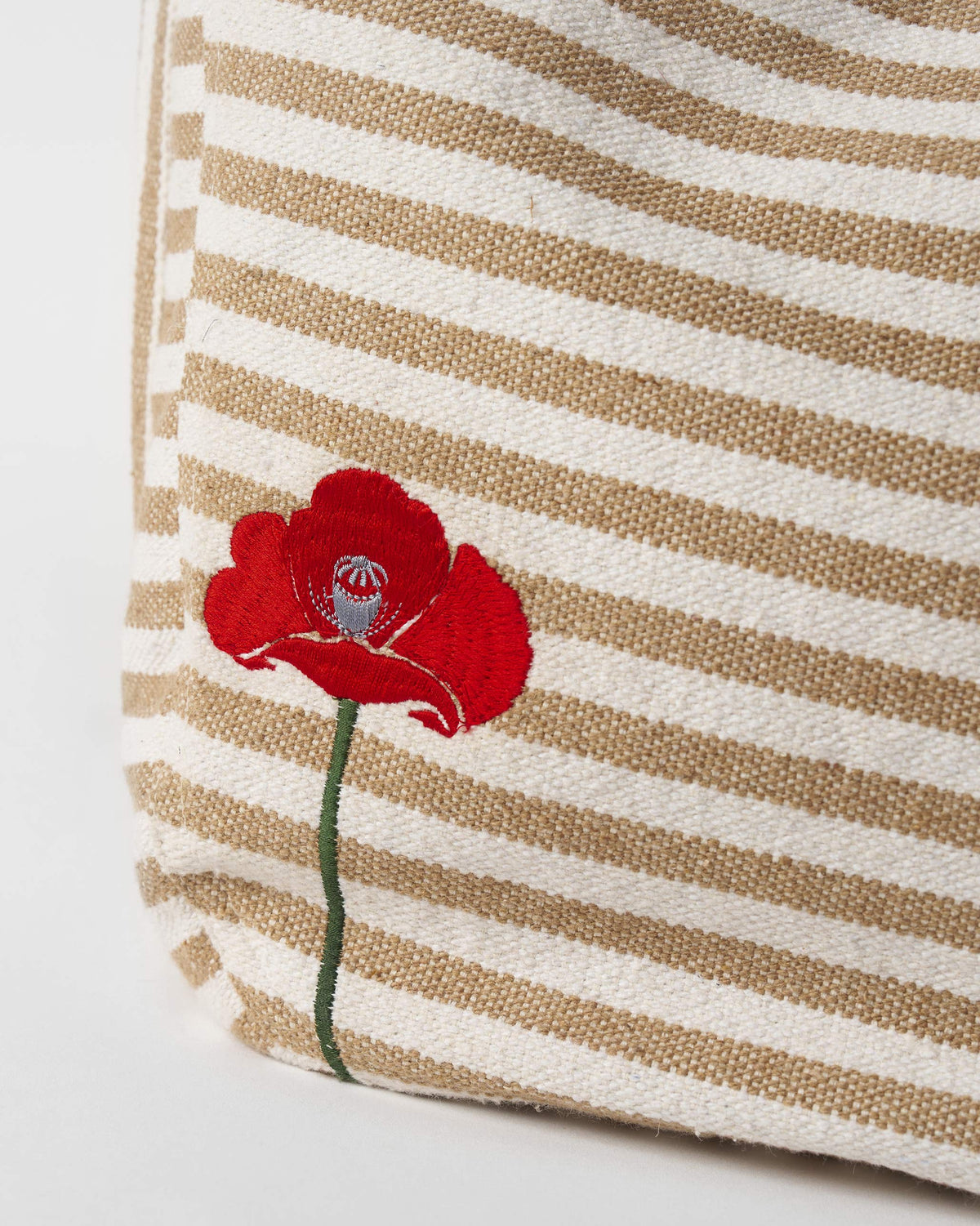 Close-up of a Wayfarer bag showing a red embroidered poppy.