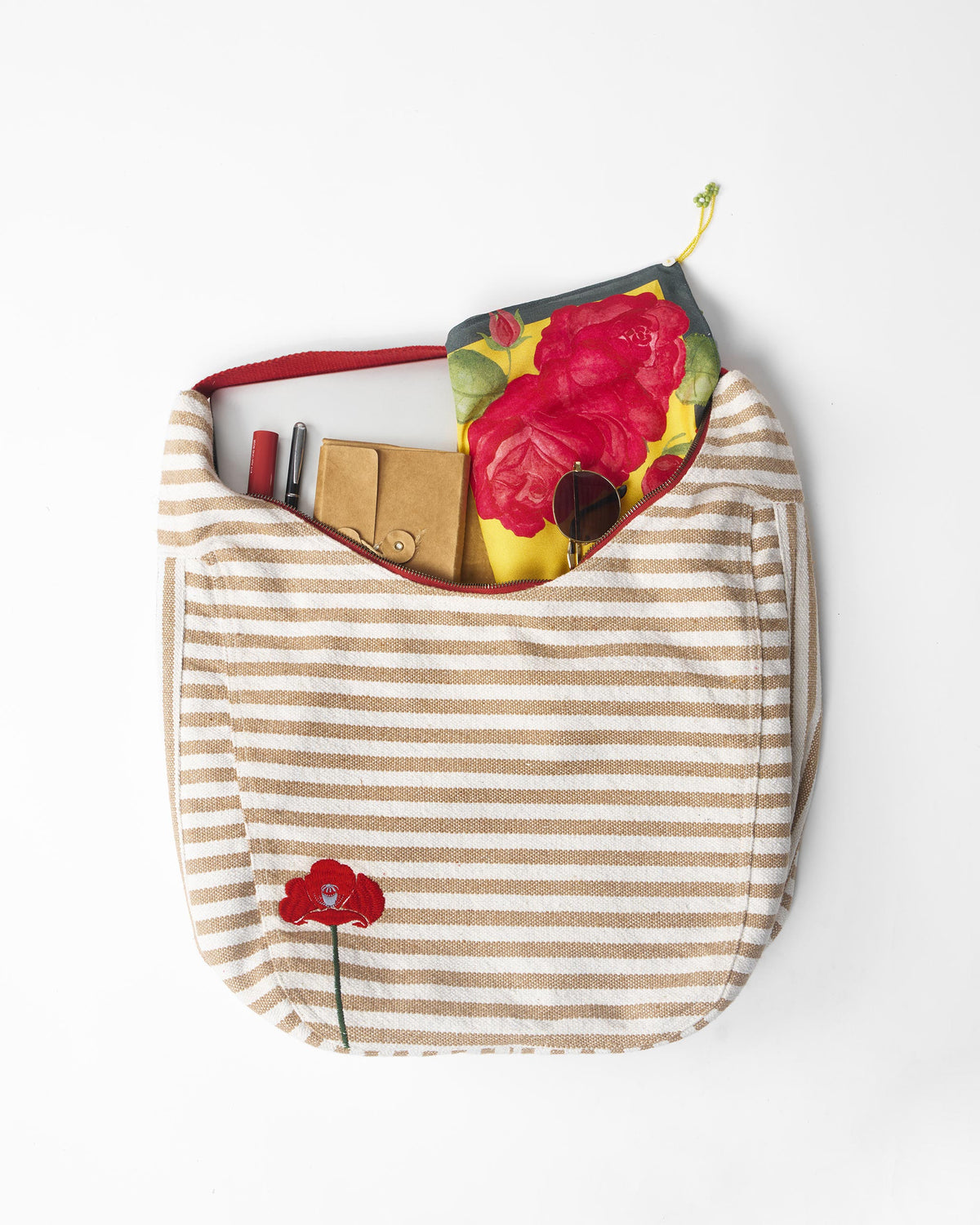 Beige striped Wayfarer bag filled with everyday essentials.