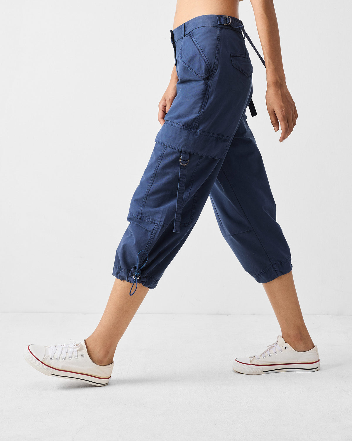 Side view of navy Vellore capris showing the cargo pocket and cinched hem.
