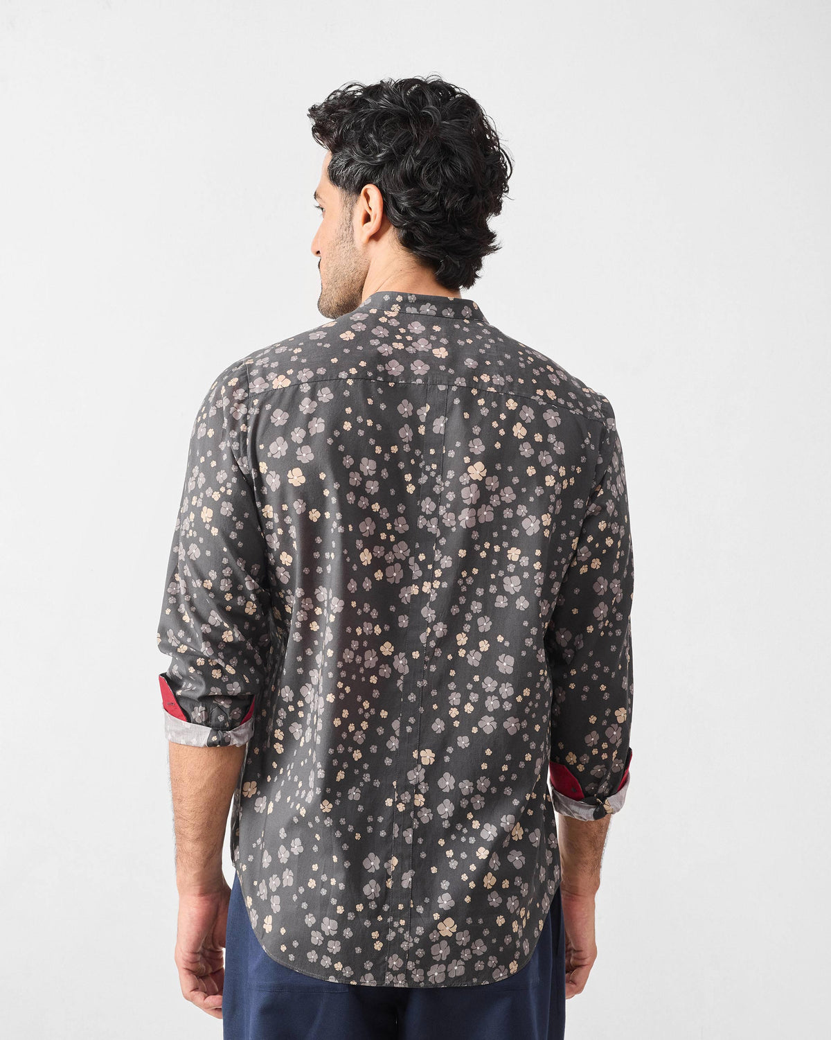 Back of a charcoal Nawab Shirt with a floral print and red contrast cuff lining.