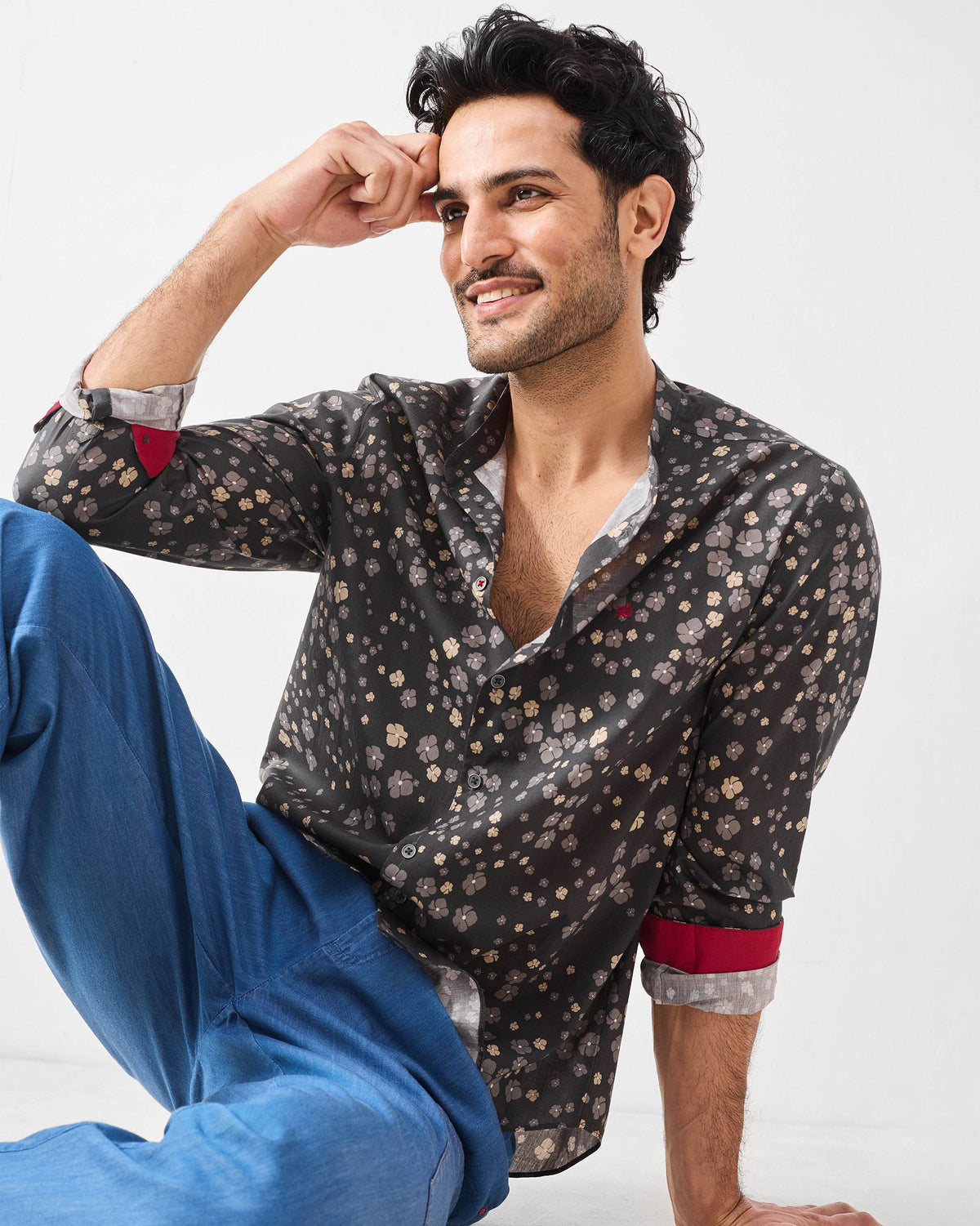Person wearing a charcoal floral Nawab Shirt with sleeves rolled to show red cuffs.