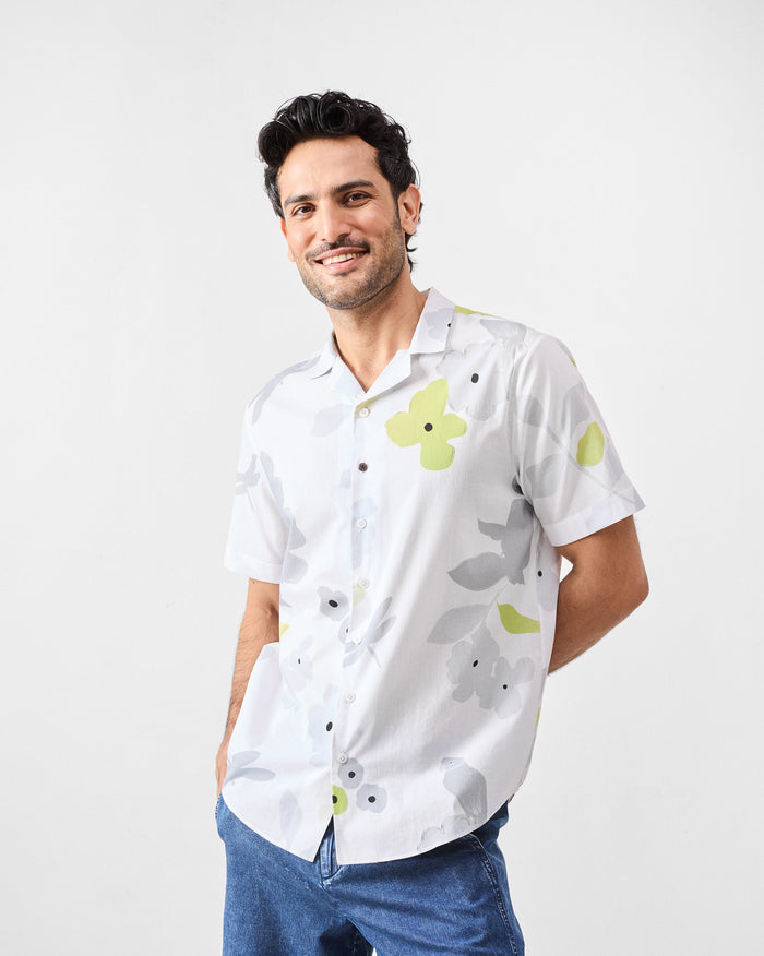 Person wearing a white Mistari Shirt with a grey and lime floral print.