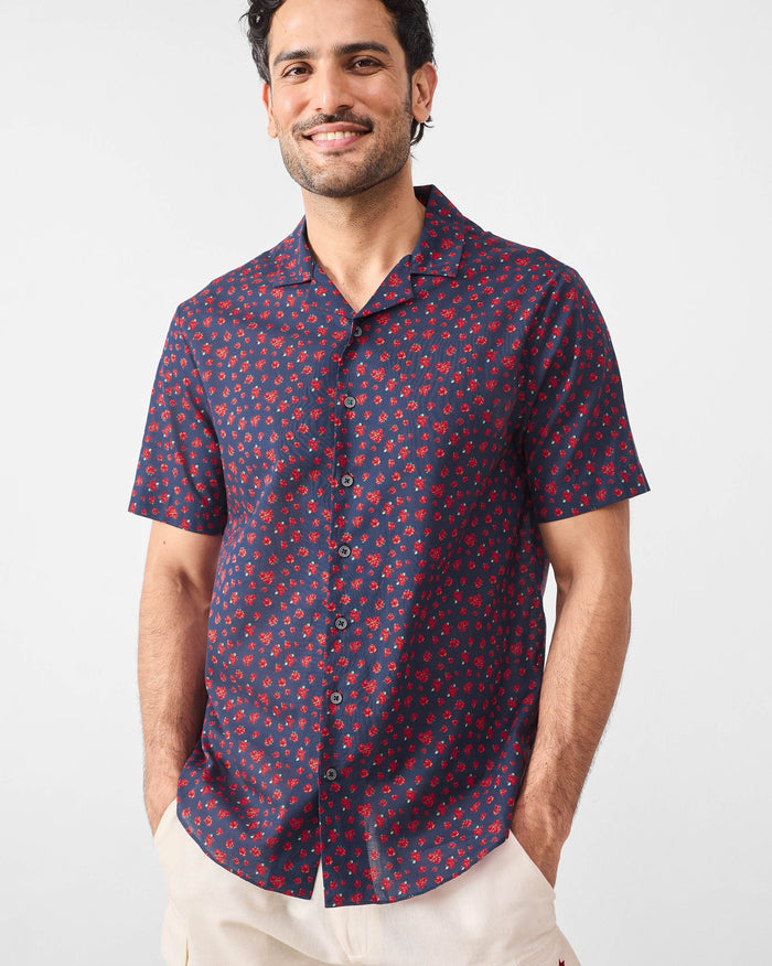 Person wearing a navy Mistari shirt with an all-over red rose print.