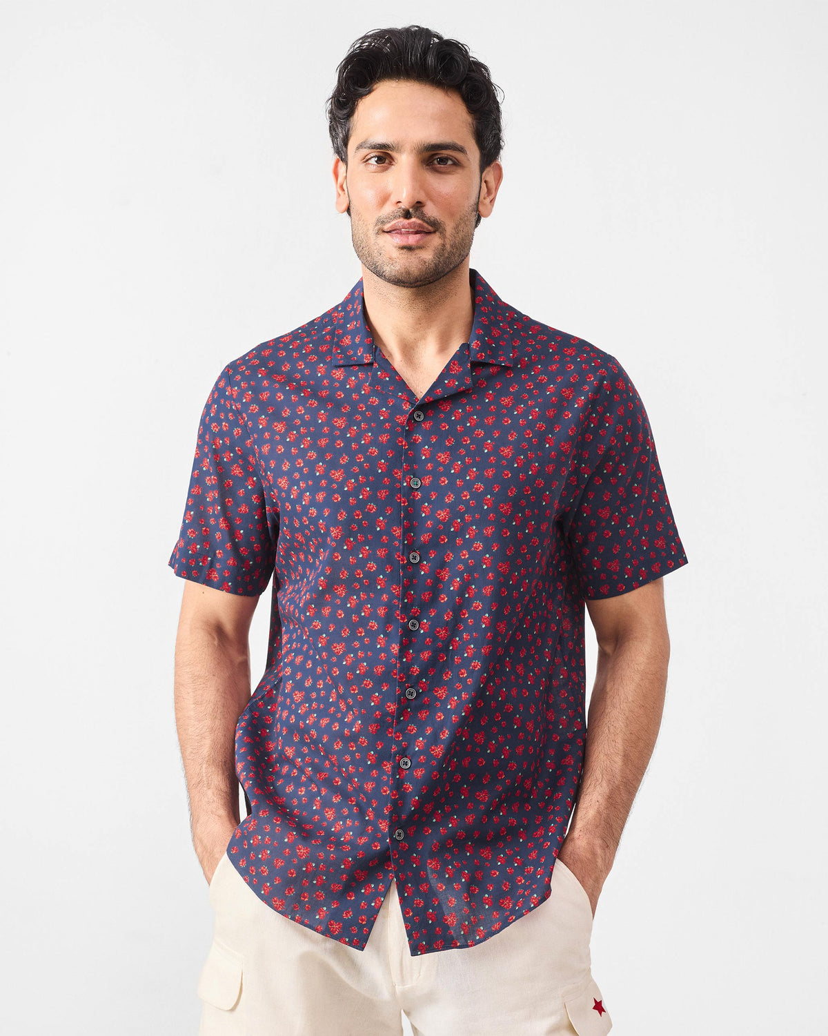 Person wearing a navy Mistari shirt with a dense red rose print.