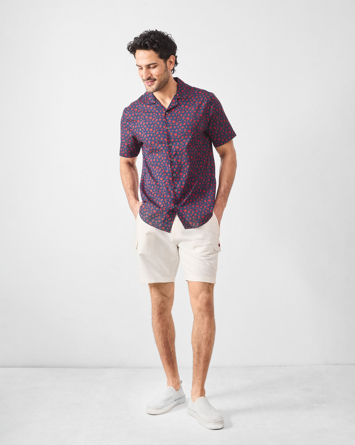 Person wearing a navy Mistari shirt with an all-over rose print.